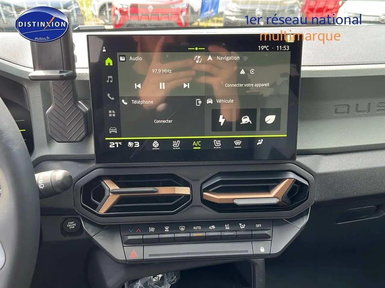 Tableau de bord du Dacia Duster 2025 avec écran tactile et aérateurs hexagonaux couleur bronze.