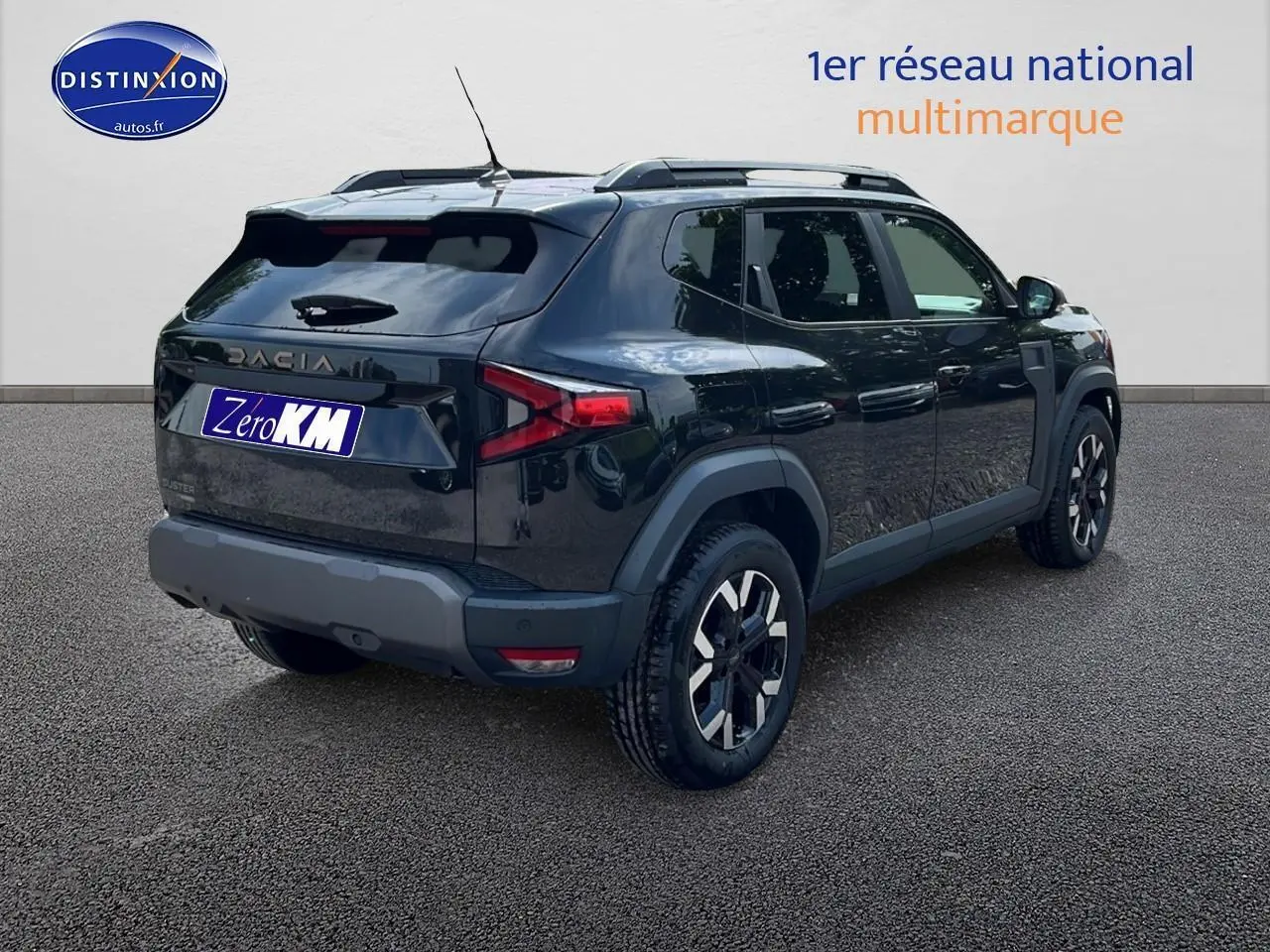 Vue 3/4 arrière droite d'un Dacia Duster noir 2025 avec jantes alu et barres de toit visibles.