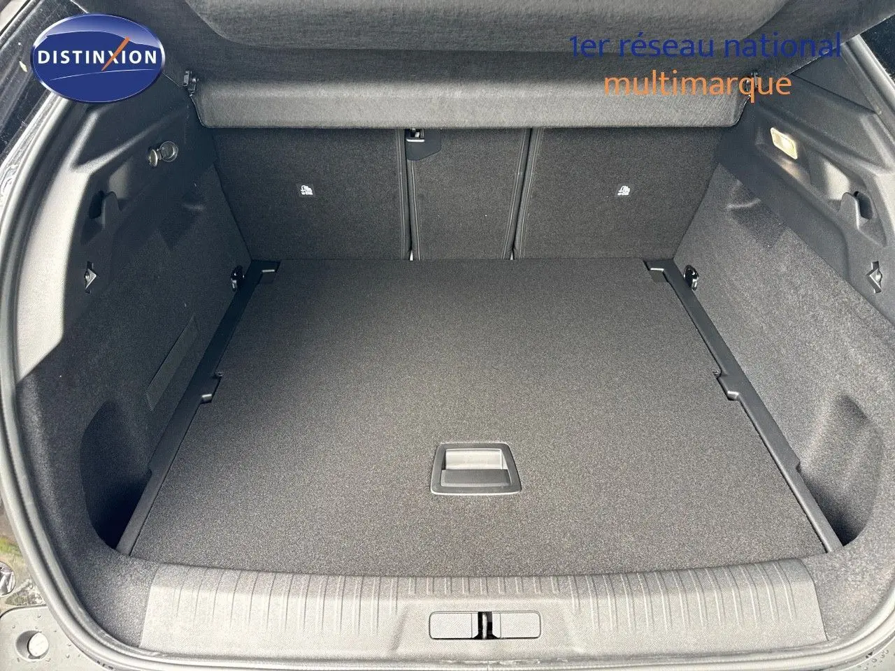 Coffre spacieux ouvert d'un Peugeot 3008 Hybrid noir perle métal, vue arrière avec plancher plat et habillage noir.