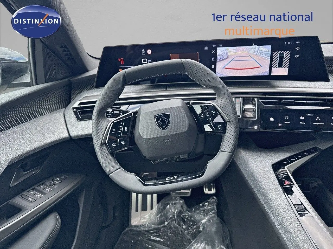 Vue intérieure centrée sur le volant cuir noir et le tableau de bord numérique du Peugeot 3008 Hybrid GT 2025.