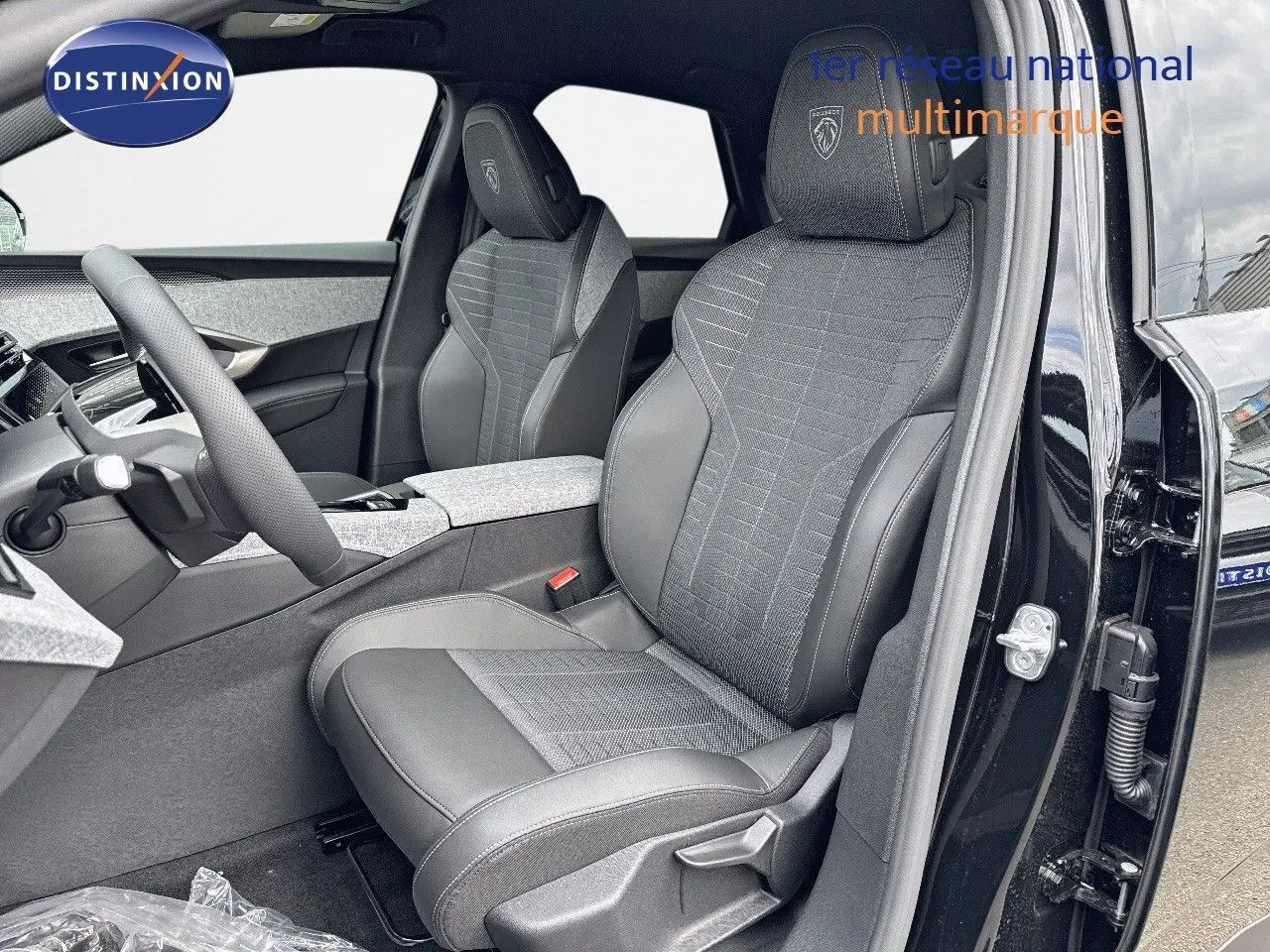 Intérieur avant droit du Peugeot 3008 Hybrid 136ch GT noir perle métal, sièges en cuir et tissu gris avec logo Peugeot.