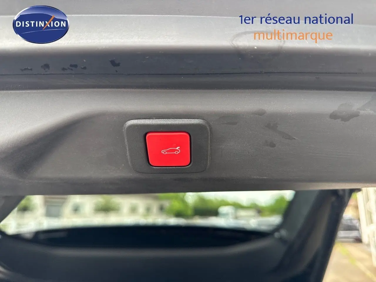 Bouton rouge d'ouverture électrique du hayon sur Peugeot 3008 noir perle métal, vue intérieure arrière du coffre.
