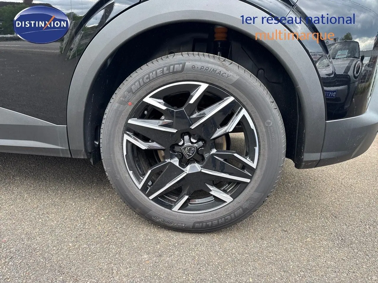 Gros plan sur la roue avant gauche noire perle métal du Peugeot 3008 Hybrid 136ch GT avec jante alliage bicolore design.