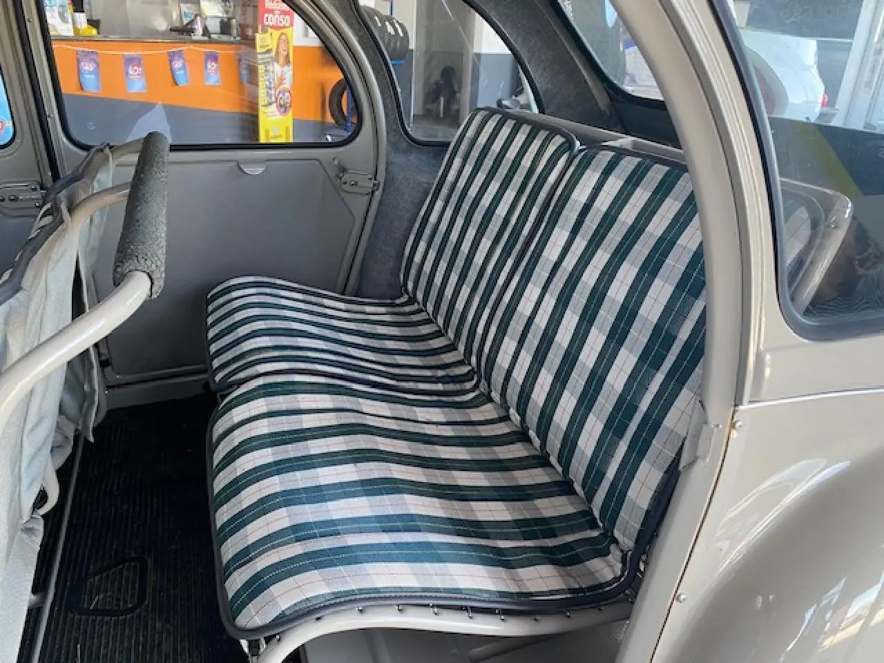 Banquette arrière à motifs rayés verts et blancs dans une Citroën 2 CV beige clair refaite à neuf, vue côté droit intérieur.