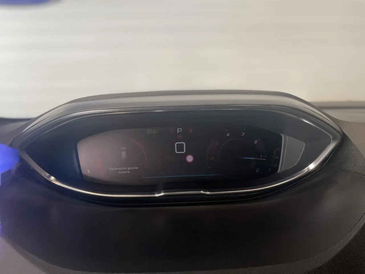 Combiné numérique du tableau de bord du Peugeot 3008 GT 2022, affichant la vitesse et alertes, entouré de chrome.