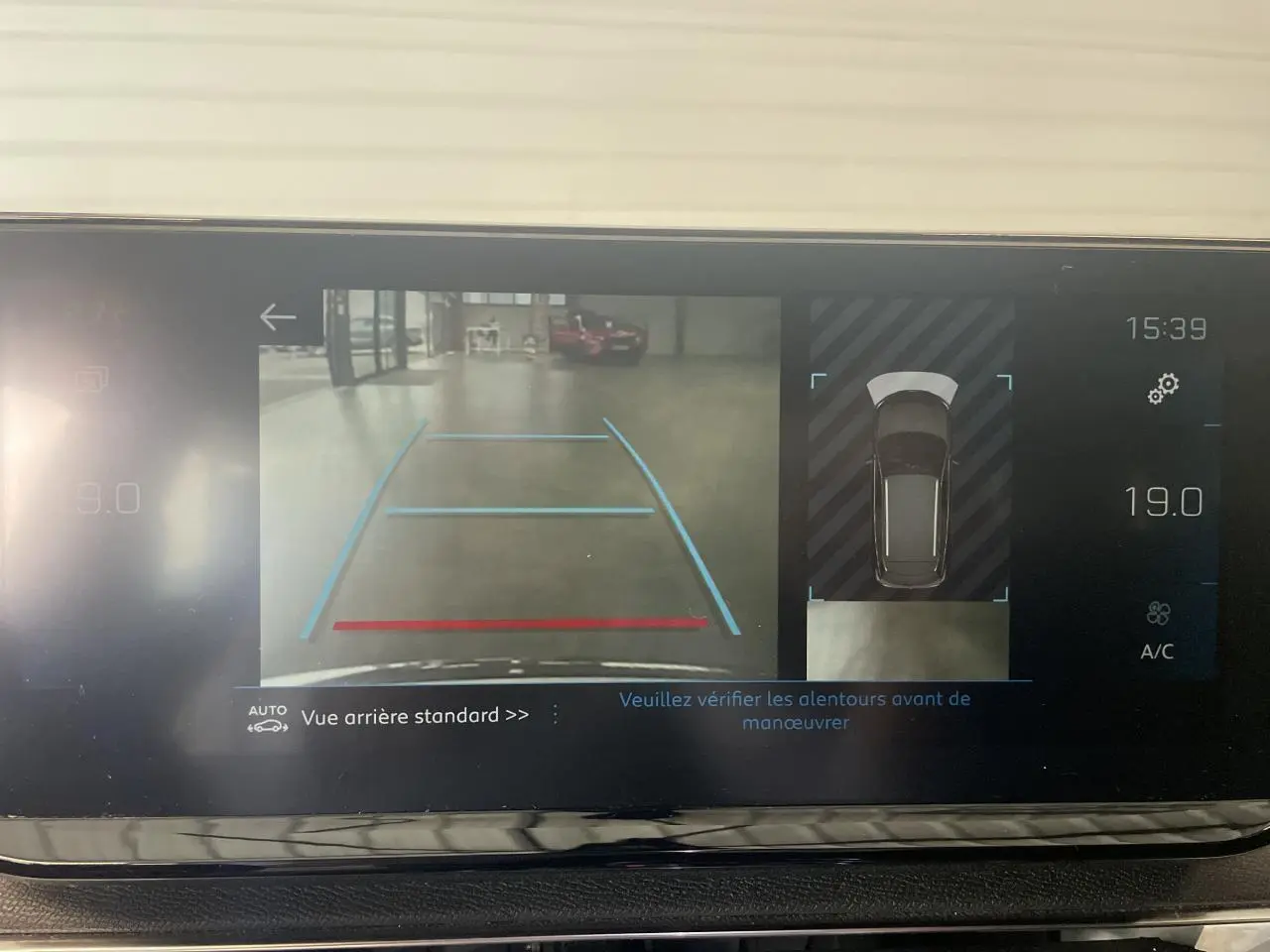 Écran de caméra de recul du Peugeot 3008 GT blanc nacré affichant les lignes d'aide au stationnement arrière.