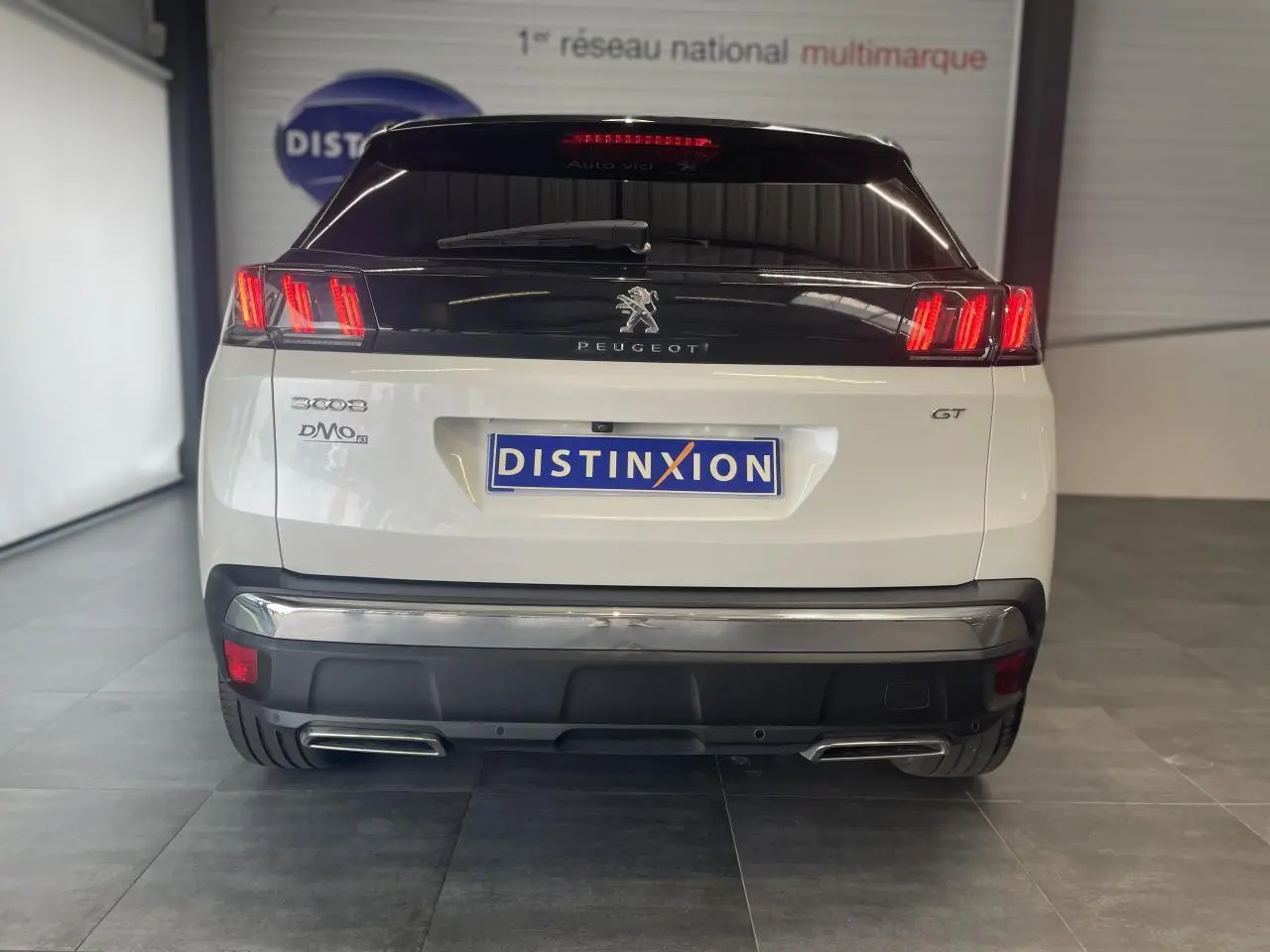 Vue arrière d'un Peugeot 3008 GT blanc nacré avec feux LED et double sortie d'échappement chromée.