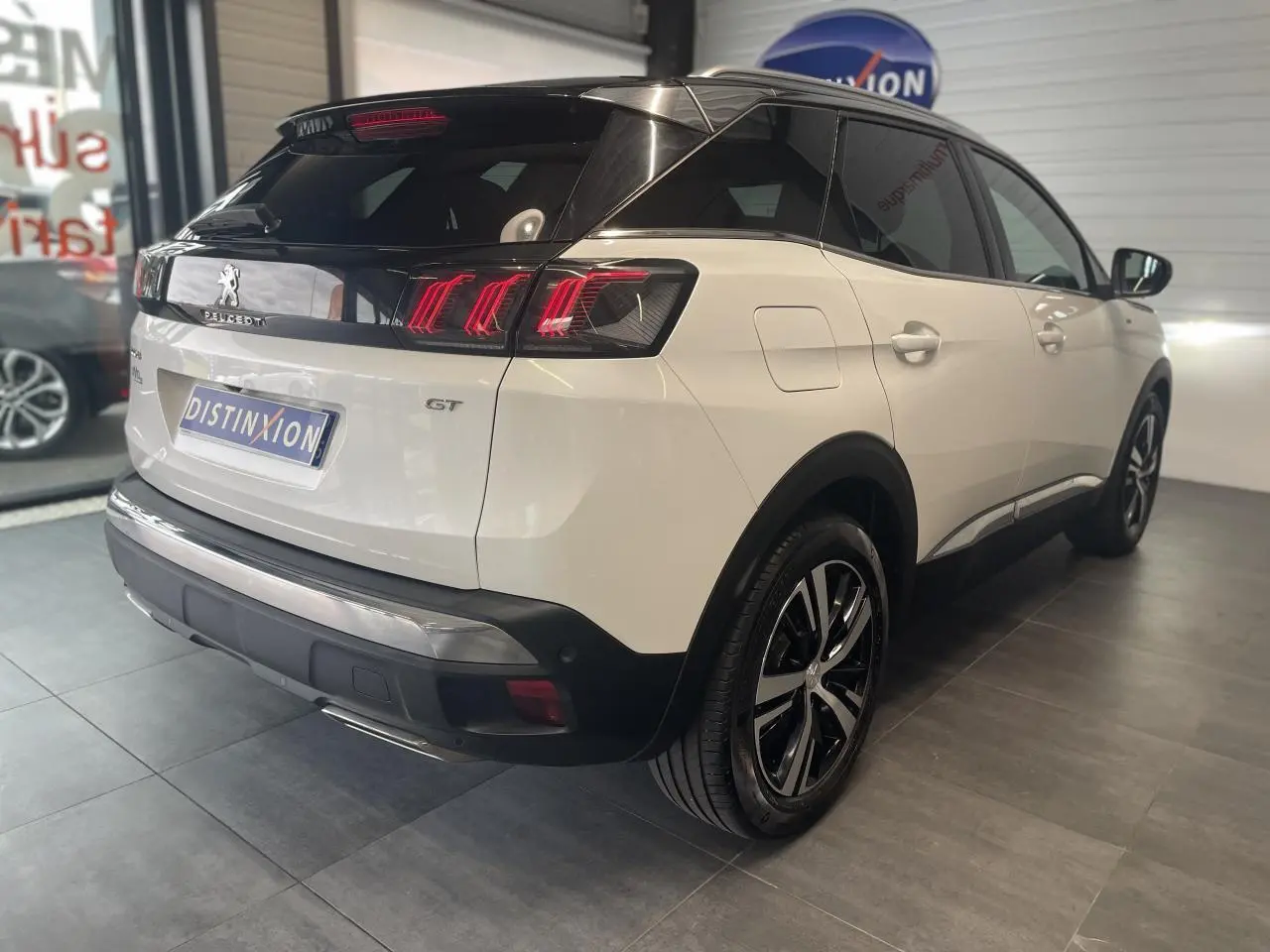 Peugeot 3008 GT blanc nacré vue 3/4 arrière droit avec toit noir et jantes alliage bi-ton.