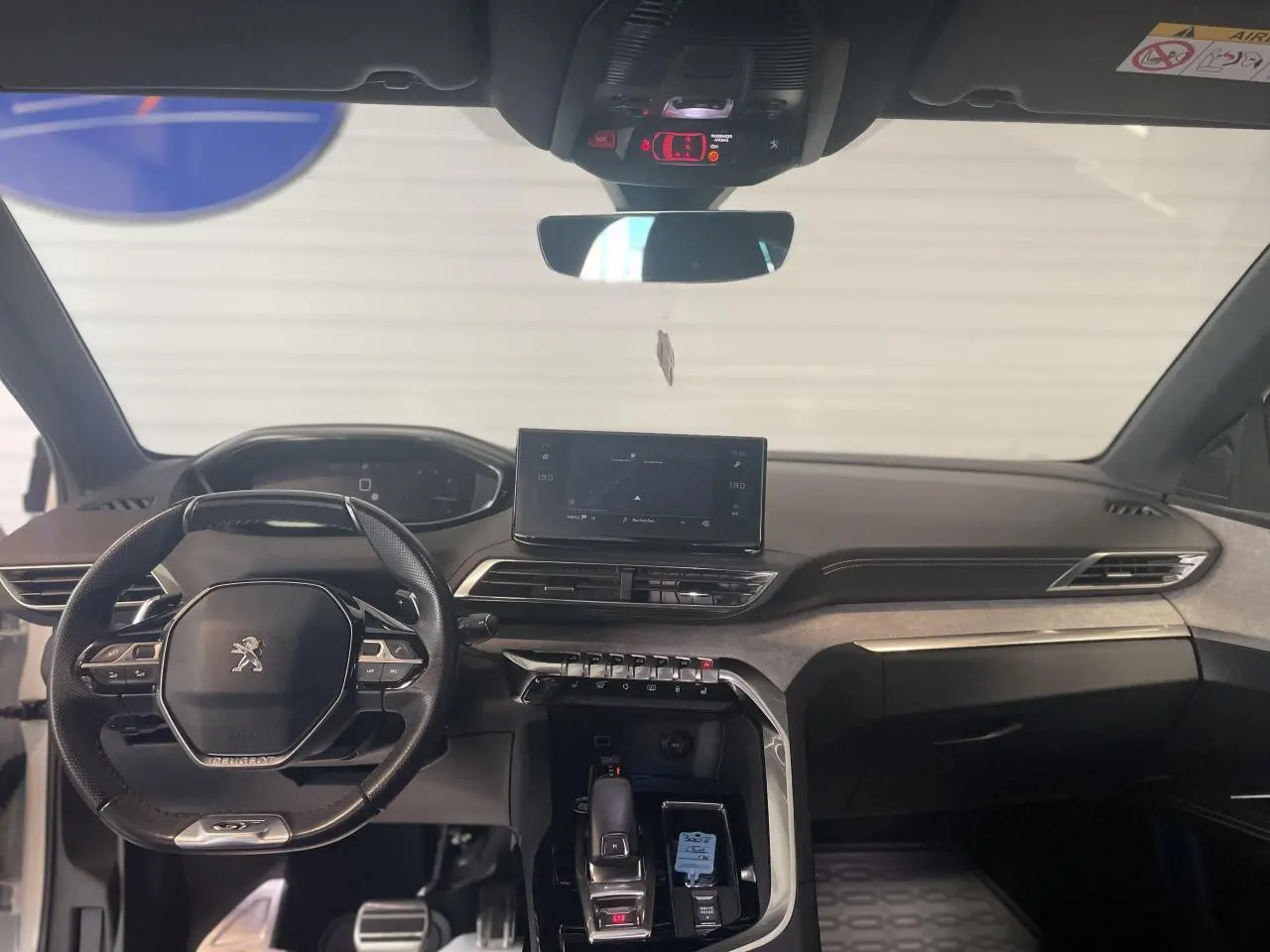 Intérieur avant du Peugeot 3008 blanc nacré 2022, tableau de bord moderne avec écran tactile et volant compact noir.