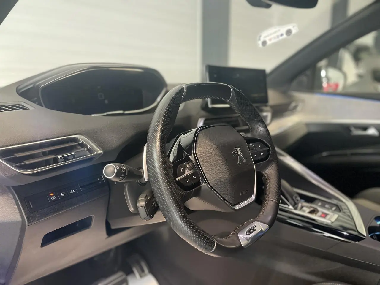 Vue intérieure du volant compact cuir perforé Peugeot 3008 GT 2022 avec tableau de bord et écran tactile.
