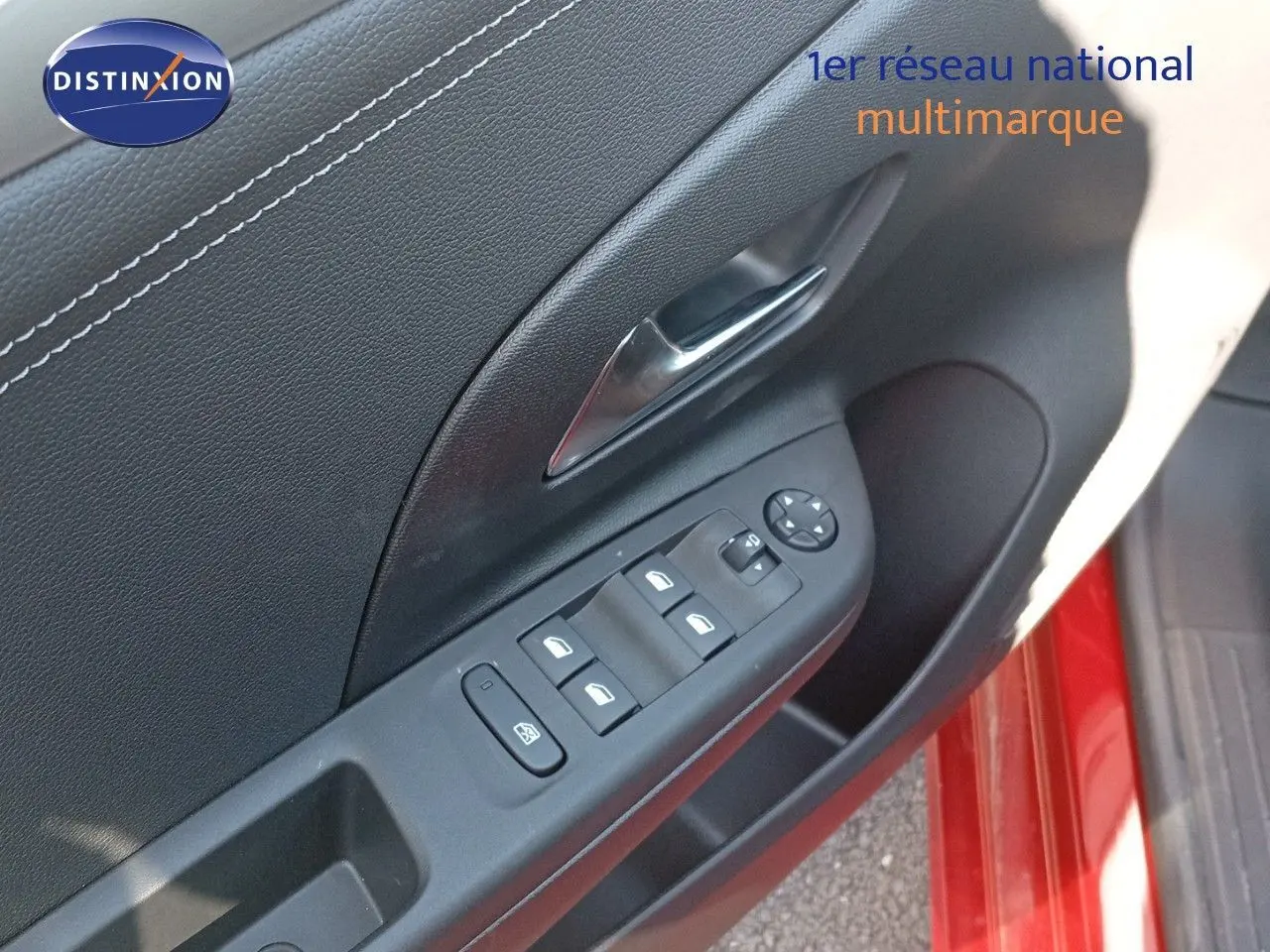 Gros plan sur la commande des vitres côté gauche d'une Opel Corsa rouge Kardio métal avec toit noir, porte ouverte.