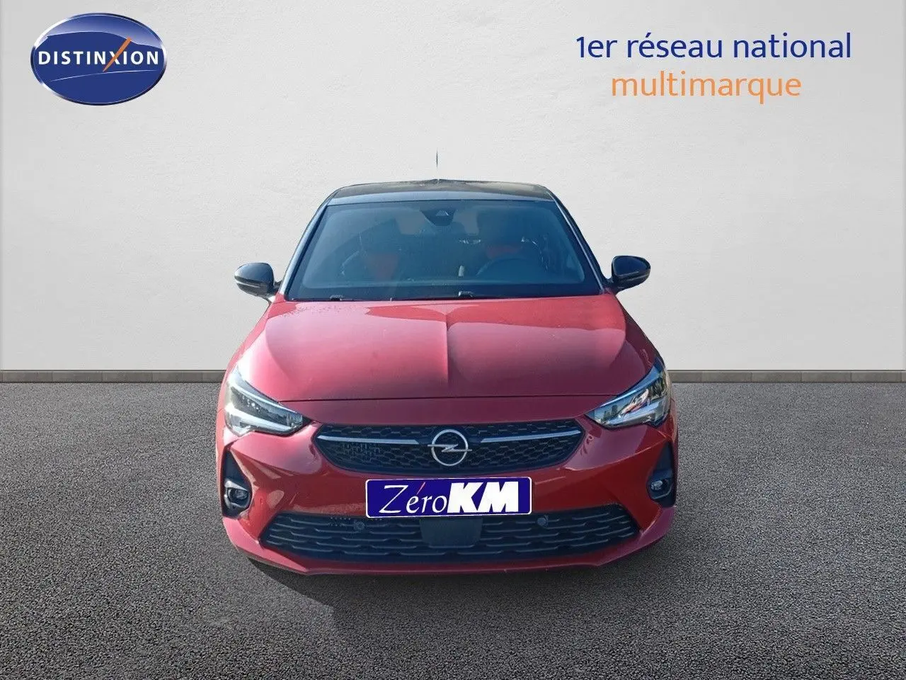 Opel Corsa 2023 rouge Kardio métal avec toit noir vue de face mettant en valeur ses phares LED et calandre noire.