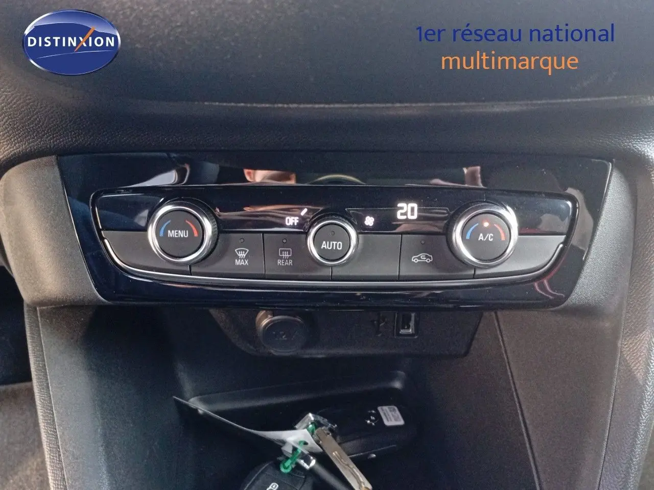 Tableau de bord de l'Opel Corsa rouge 2023, vue frontale centrée sur la console de climatisation digitale.