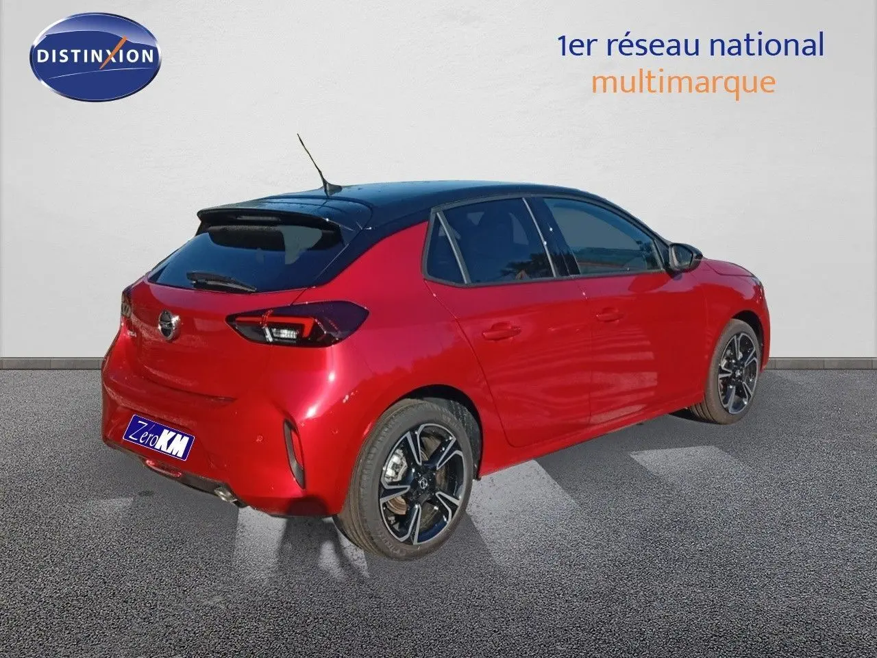 Vue 3/4 arrière droite d'une Opel Corsa rouge Kardio métal avec toit noir et jantes alliage noires.
