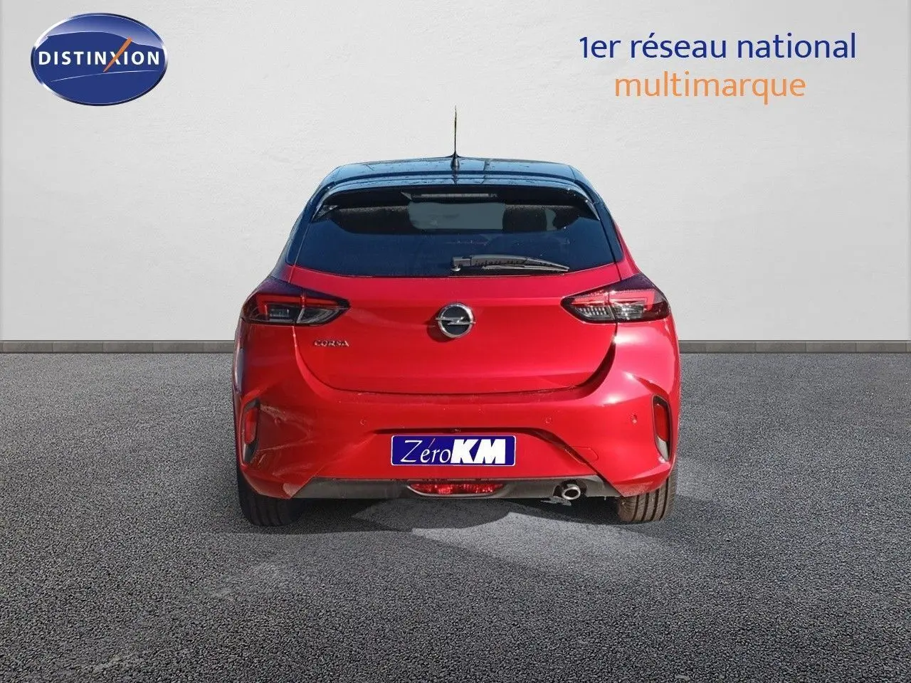 Vue arrière d'une Opel Corsa rouge Kardio métal avec toit noir, affichant son logo et feux LED distinctifs.