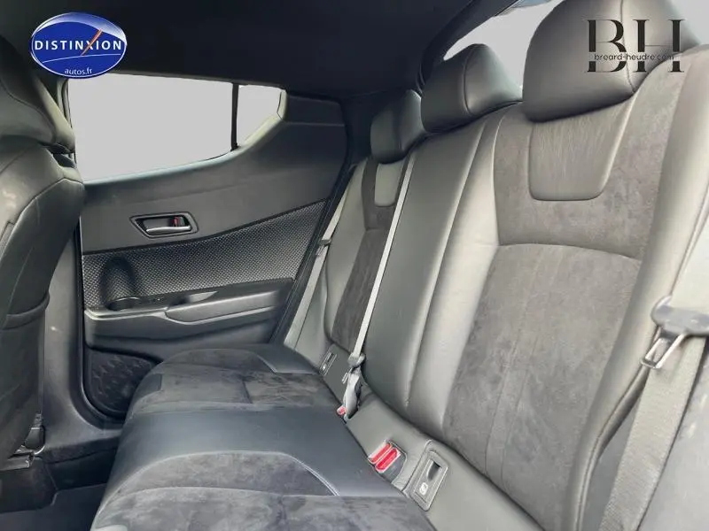 Vue intérieure de la banquette arrière en cuir noir et alcantara du Toyota C-HR blanc nacré, côté gauche.
