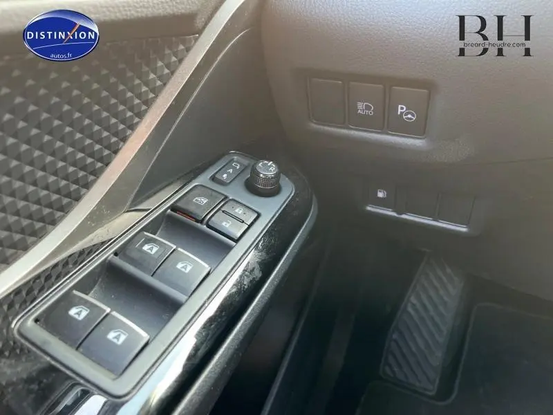 Vue rapprochée des commandes de vitres et rétroviseurs côté conducteur du Toyota C-HR blanc nacré 2019.