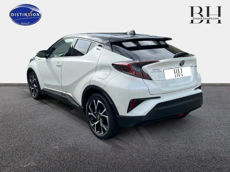 Vue 3/4 arrière droite du Toyota C-HR 122h Collection blanc nacré bi-ton avec jantes alu et feux LED distinctifs.