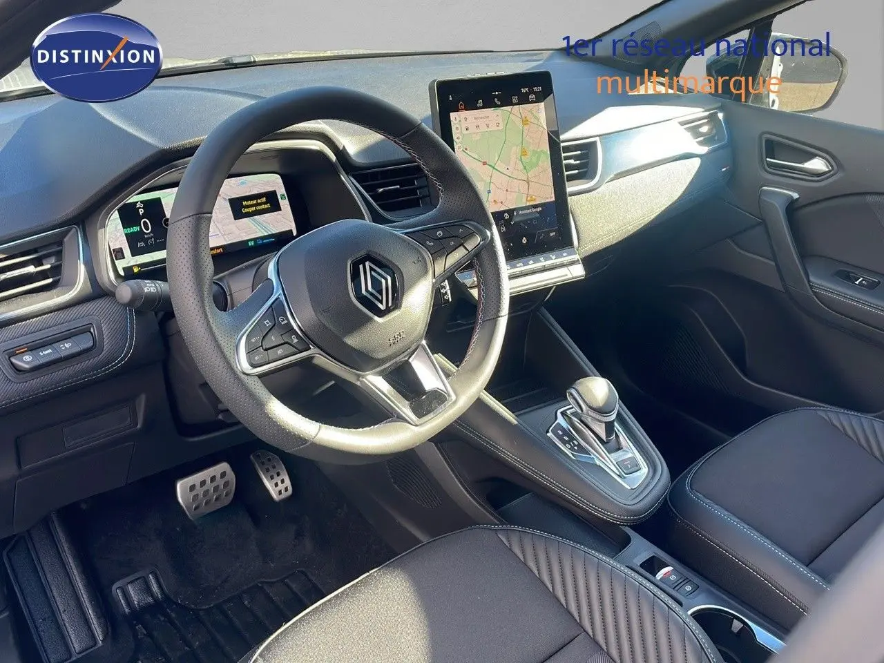 Intérieur avant droit du Renault Captur E-Tech hybride 2025 avec volant multifonction et écran tactile vertical.