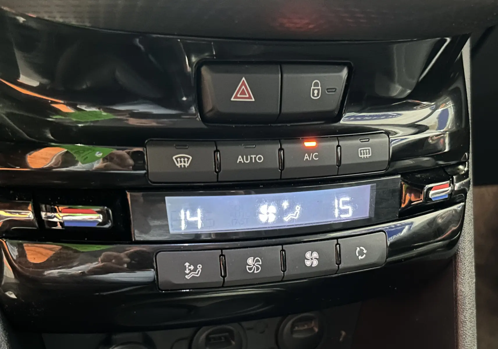 Détail du tableau de bord noir avec commandes de climatisation digitale du Peugeot 2008 blanc VTi 82 Allure 2014.