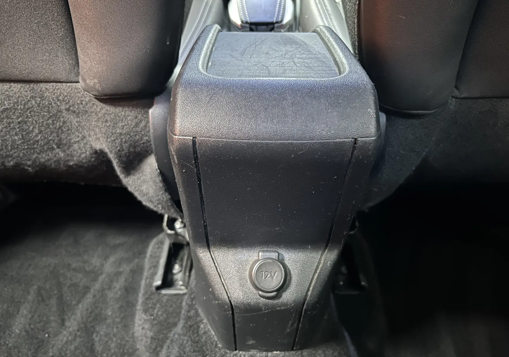 Vue rapprochée du coffre central arrière noir avec prise 12V du Peugeot 2008 blanc VTi 82 Allure de 2014.