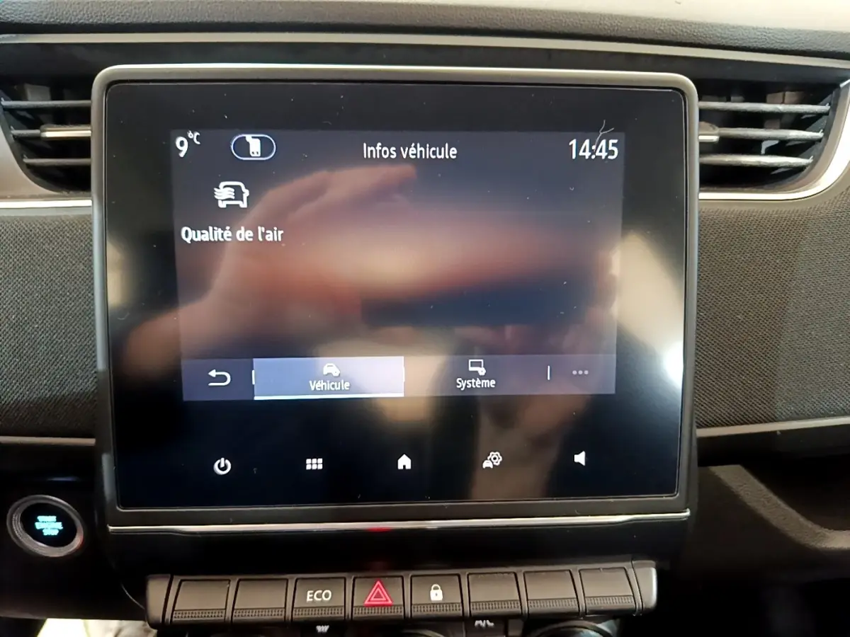 Écran tactile central affichant les infos véhicule dans l’habitacle noir d’une Renault ZOE blanche de 2021.