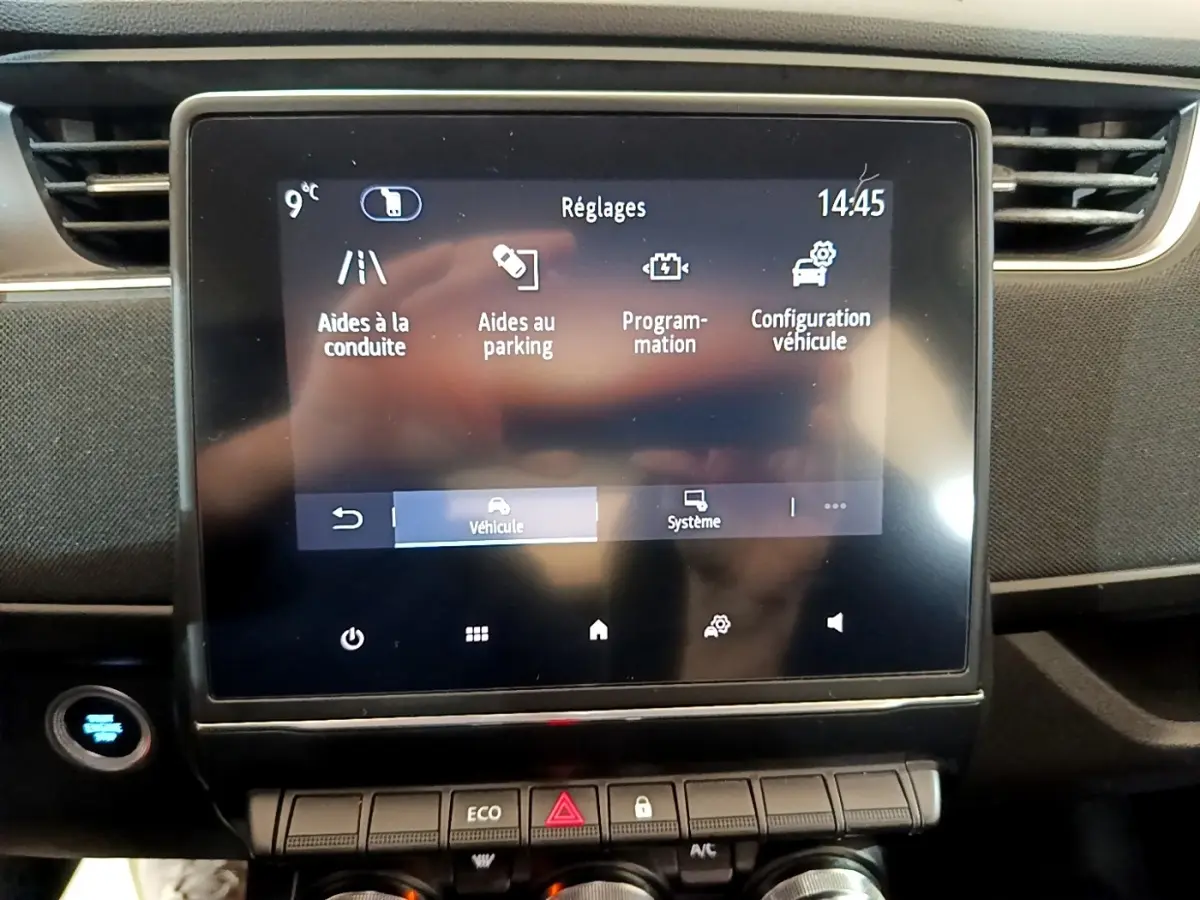 Écran tactile central de la Renault ZOE Business R110 blanc, affichant les réglages d’aides à la conduite et parking.