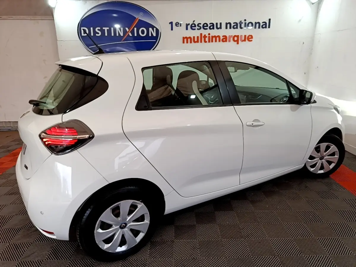 Vue 3/4 arrière droite d'une Renault ZOE Business R110 blanche, avec feux arrière LED et jantes acier.