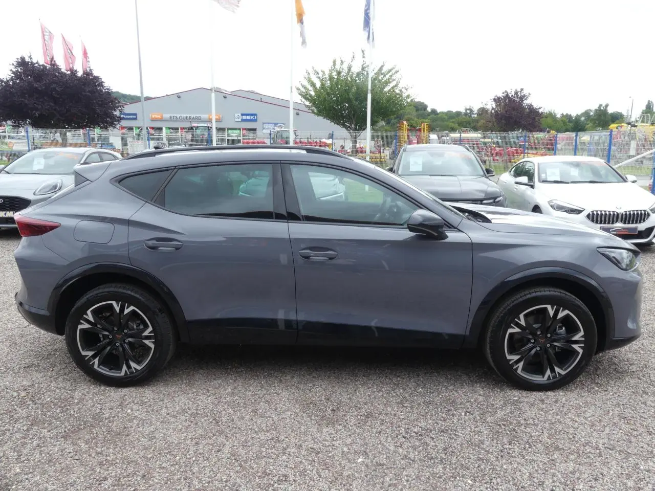 Profil droit du CUPRA Formentor gris Graphène avec jantes alliage noires et coques de rétroviseurs noires contrastantes.