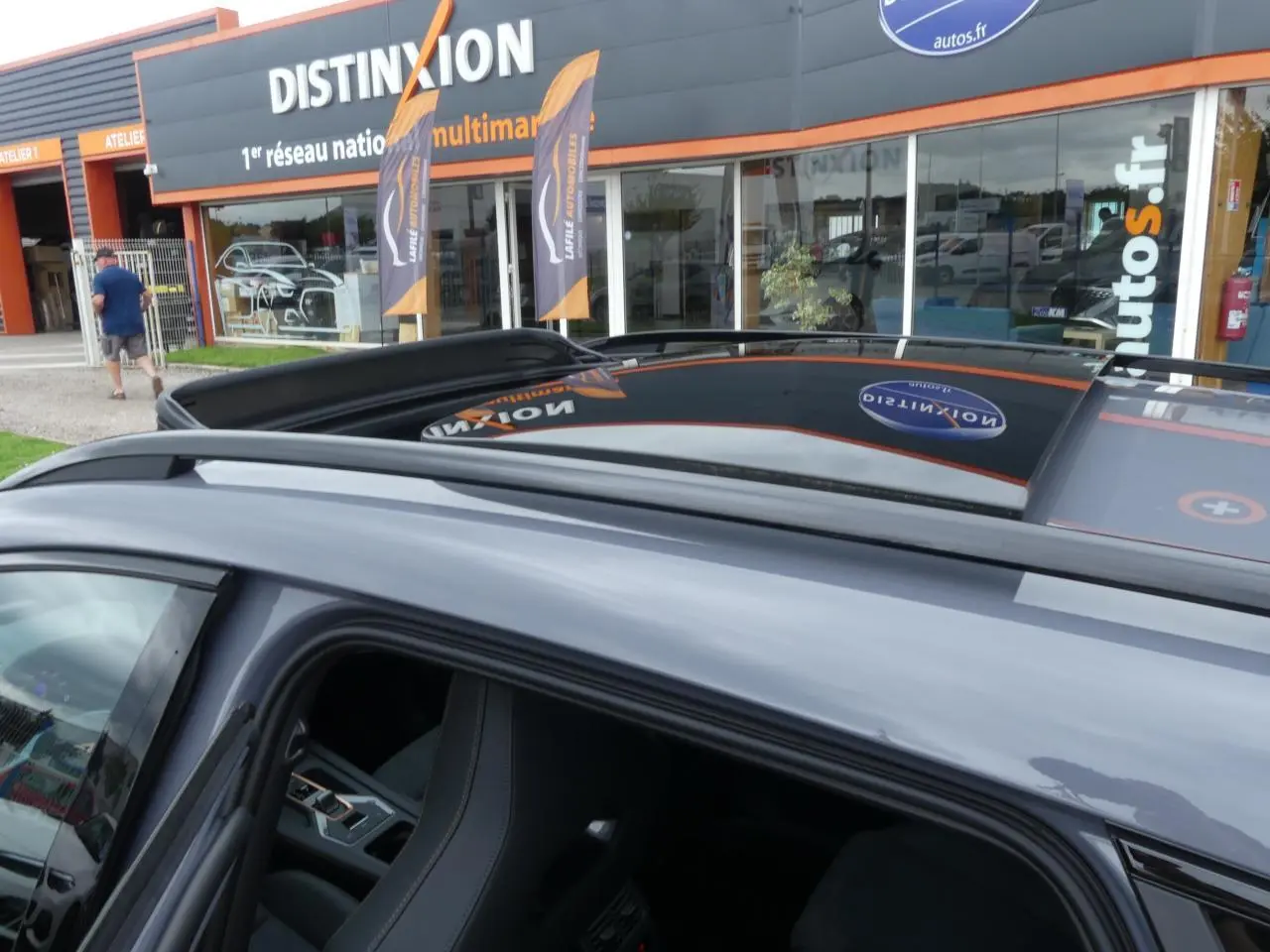 Toit ouvrant panoramique ouvert sur un CUPRA Formentor gris Graphène vu de dessus côté gauche, avec barres de toit noires.