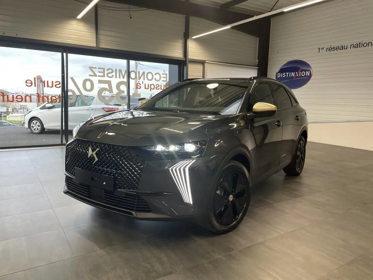 DS7 Crossback gris titanium en 3/4 avant droit avec calandre noire et coques de rétroviseurs dorées satinées.