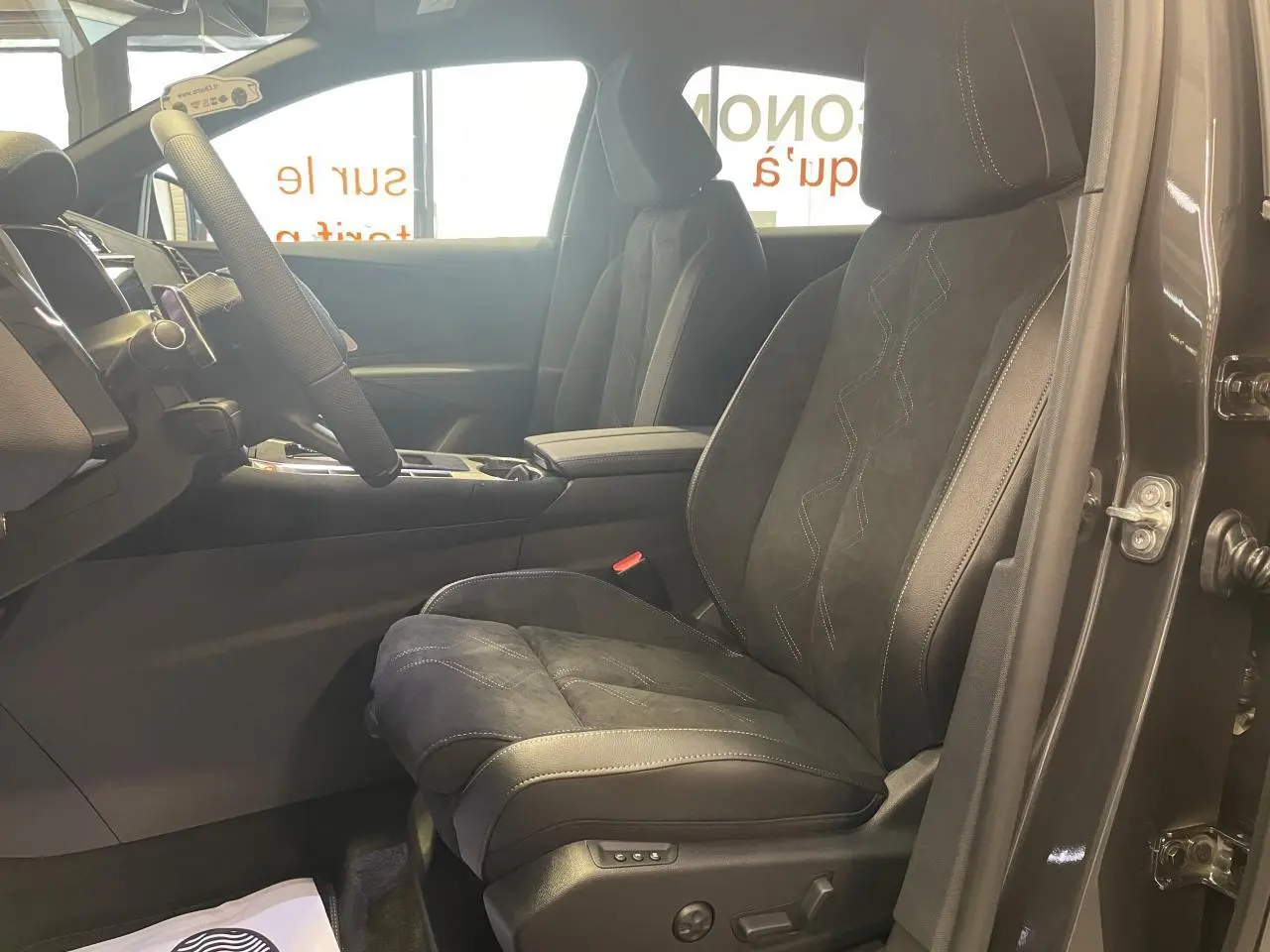 Vue intérieure côté conducteur du DS7 Crossback gris titanium, sièges en Alcantara noir avec surpiqûres visibles.