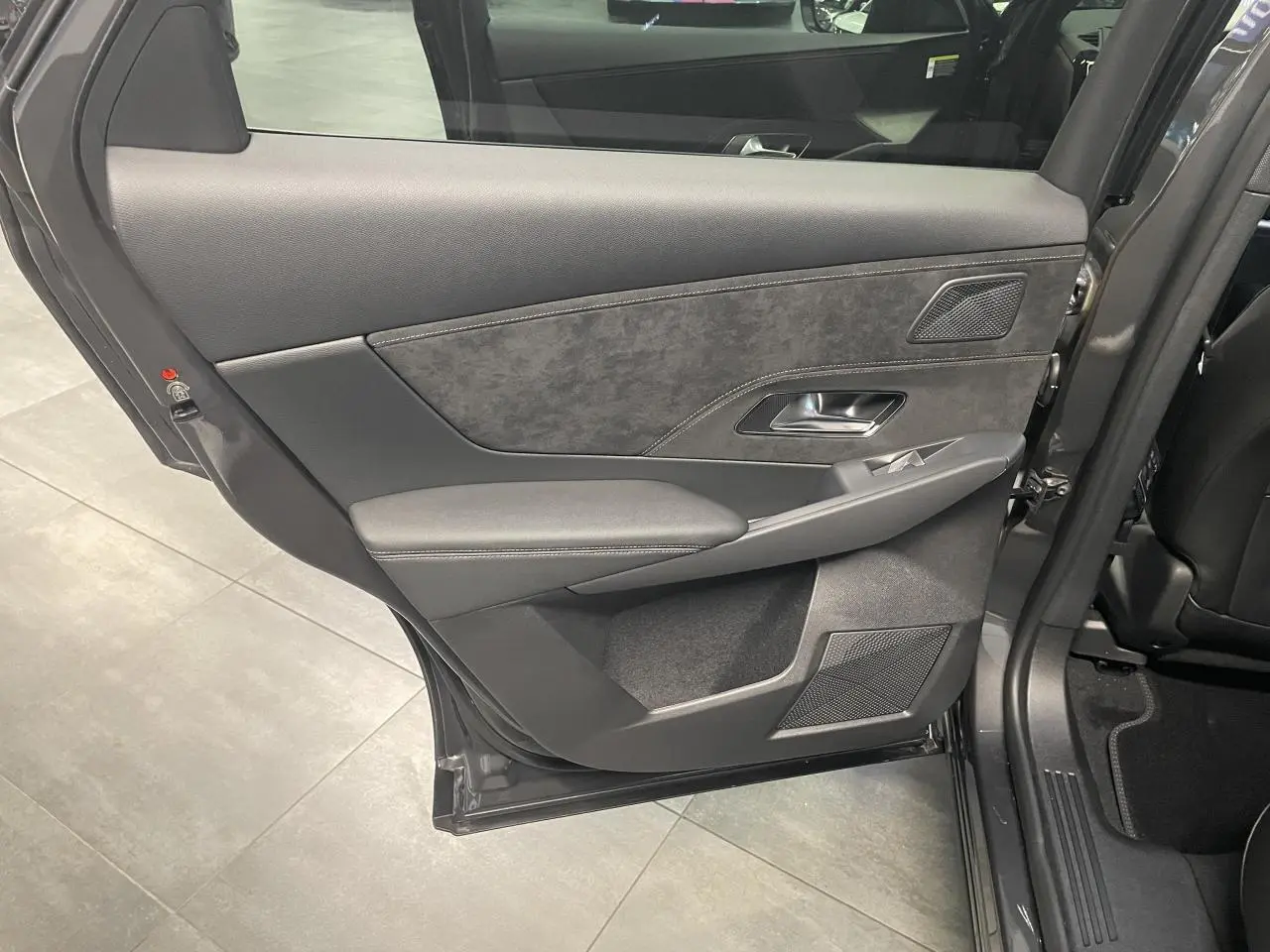 Vue rapprochée de la porte arrière gauche gris titanium du DS7 Crossback avec garniture Alcantara et commandes de fenêtre.