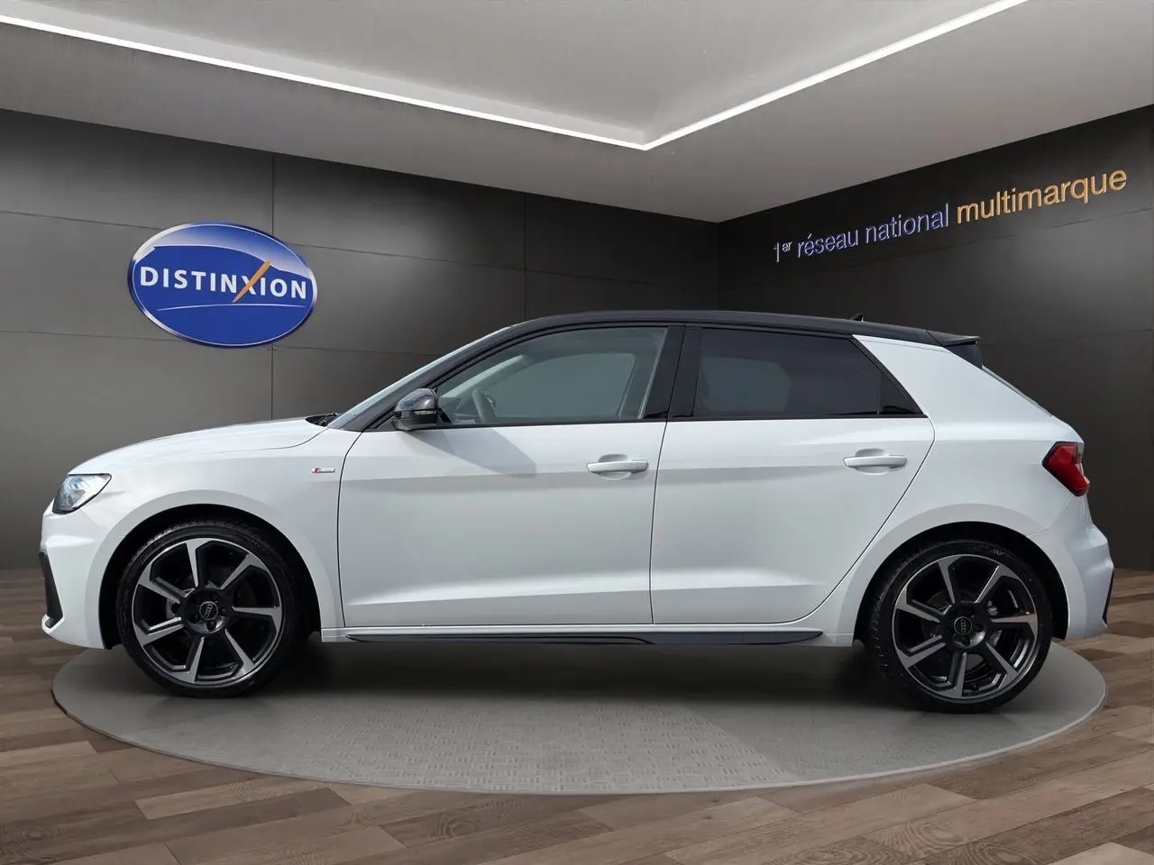 Audi A1 Sportback blanc avec toit noir, vue de profil côté gauche, jantes 18 pouces bicolores et vitres surteintées.