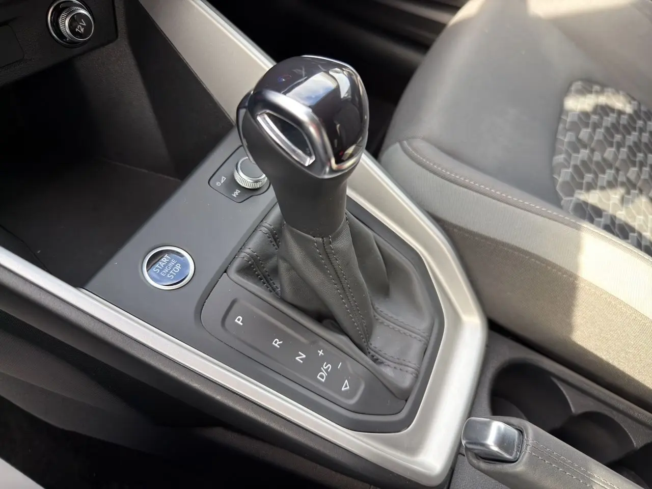 Le levier de vitesses automatique noir et argenté de l'Audi A1 Sportback 2025 vu en gros plan côté console centrale.