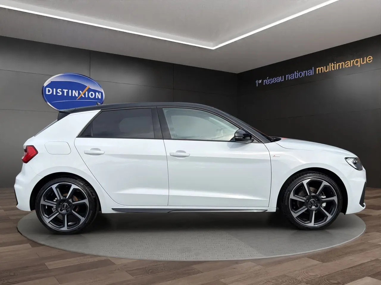 Audi A1 Sportback blanc à toit noir en vue profil droit, avec jantes 18 pouces bicolores et vitres arrière surteintées.