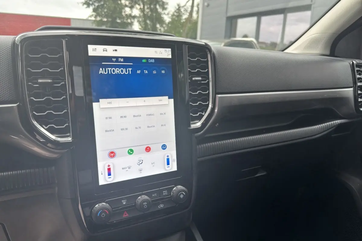 Vue intérieure du tableau de bord du Ford Ranger 2026 avec écran tactile vertical et commandes climatisation visibles.