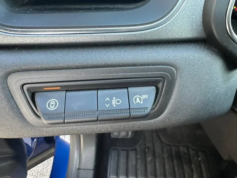Détail des commandes sous le tableau de bord du Renault Captur 2025 Bleu Iron/Noir Etoilé, avec boutons de verrouillage et réglage des phares.