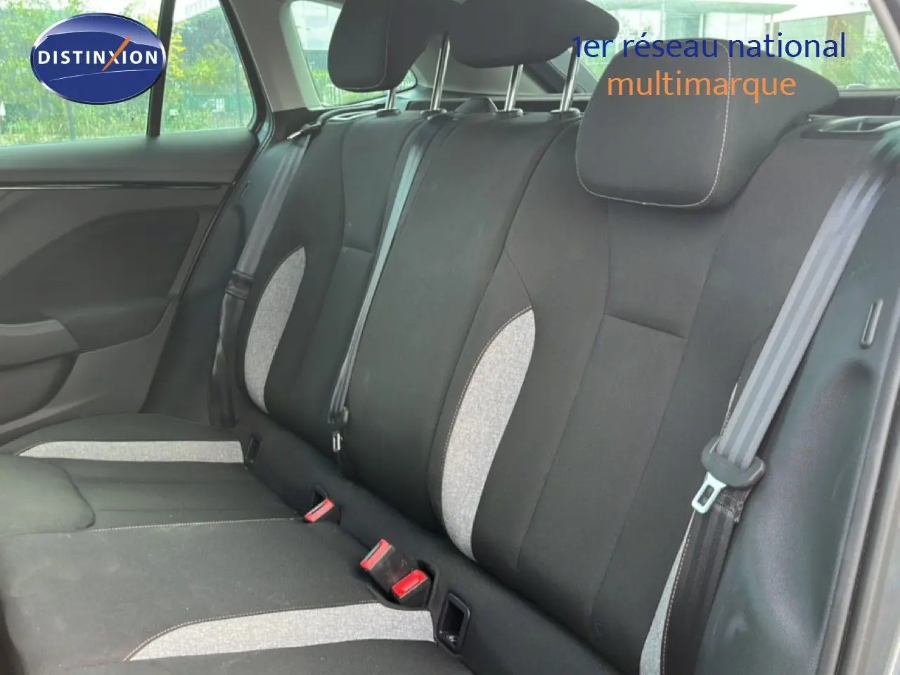 Vue intérieure des sièges arrière en tissu noir et gris clair d'une Skoda Scala 2025, avec ceintures de sécurité visibles.