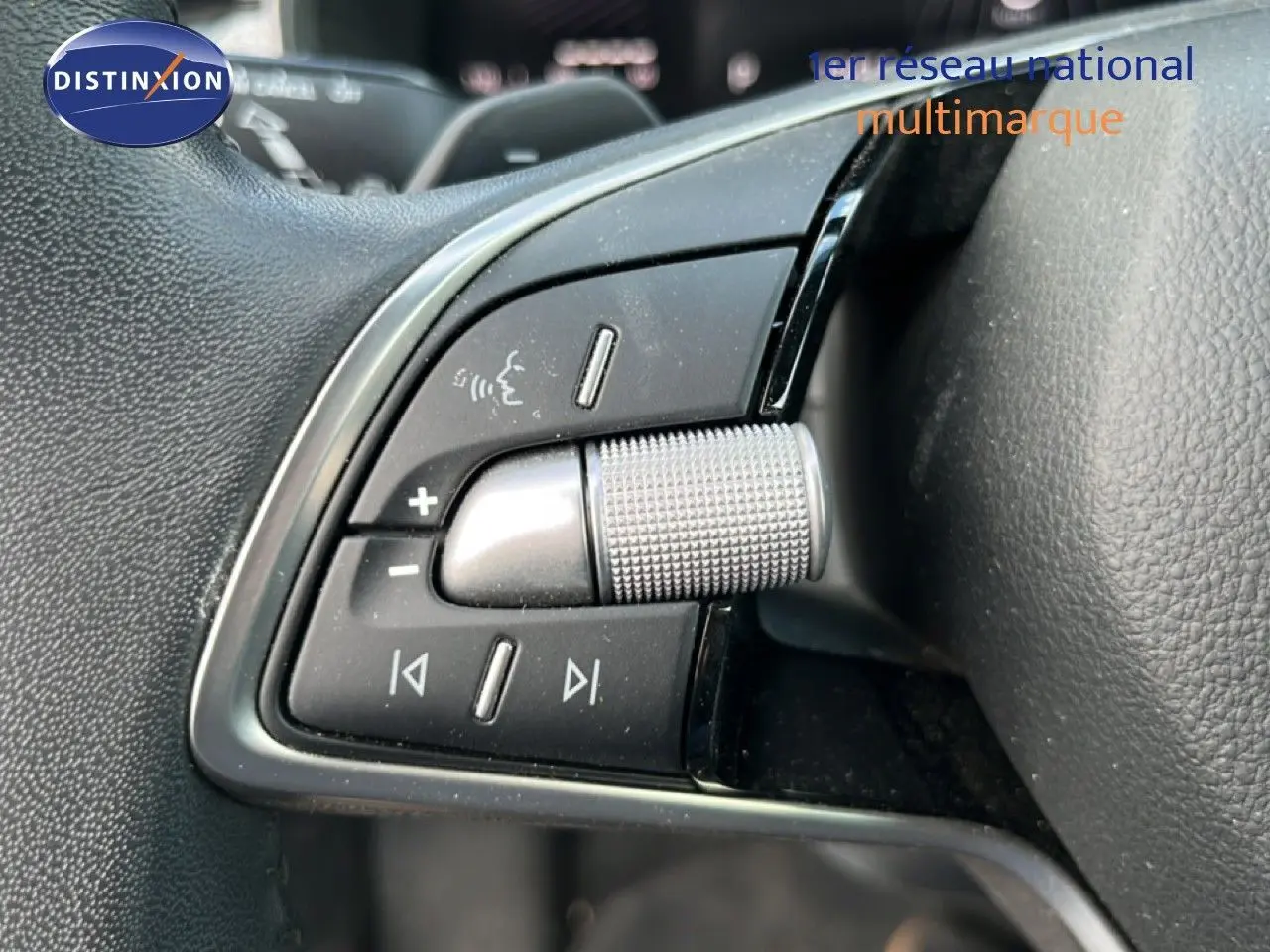 Gros plan sur les commandes de volume et multimédia au volant d’une Skoda Scala gris magnétique, finition 2025.