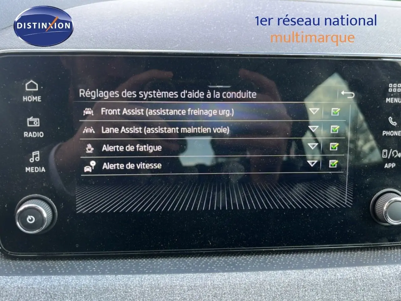 Écran tactile intérieur affichant les réglages d’aide à la conduite sur Skoda Scala gris magnétique, vue frontale.