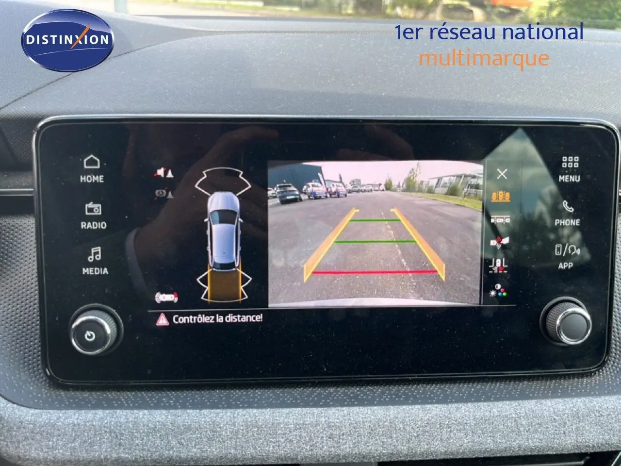 Écran multimédia affichant la caméra de recul et l’alerte de distance du Skoda Scala gris magnétique, vue intérieure tableau de bord.