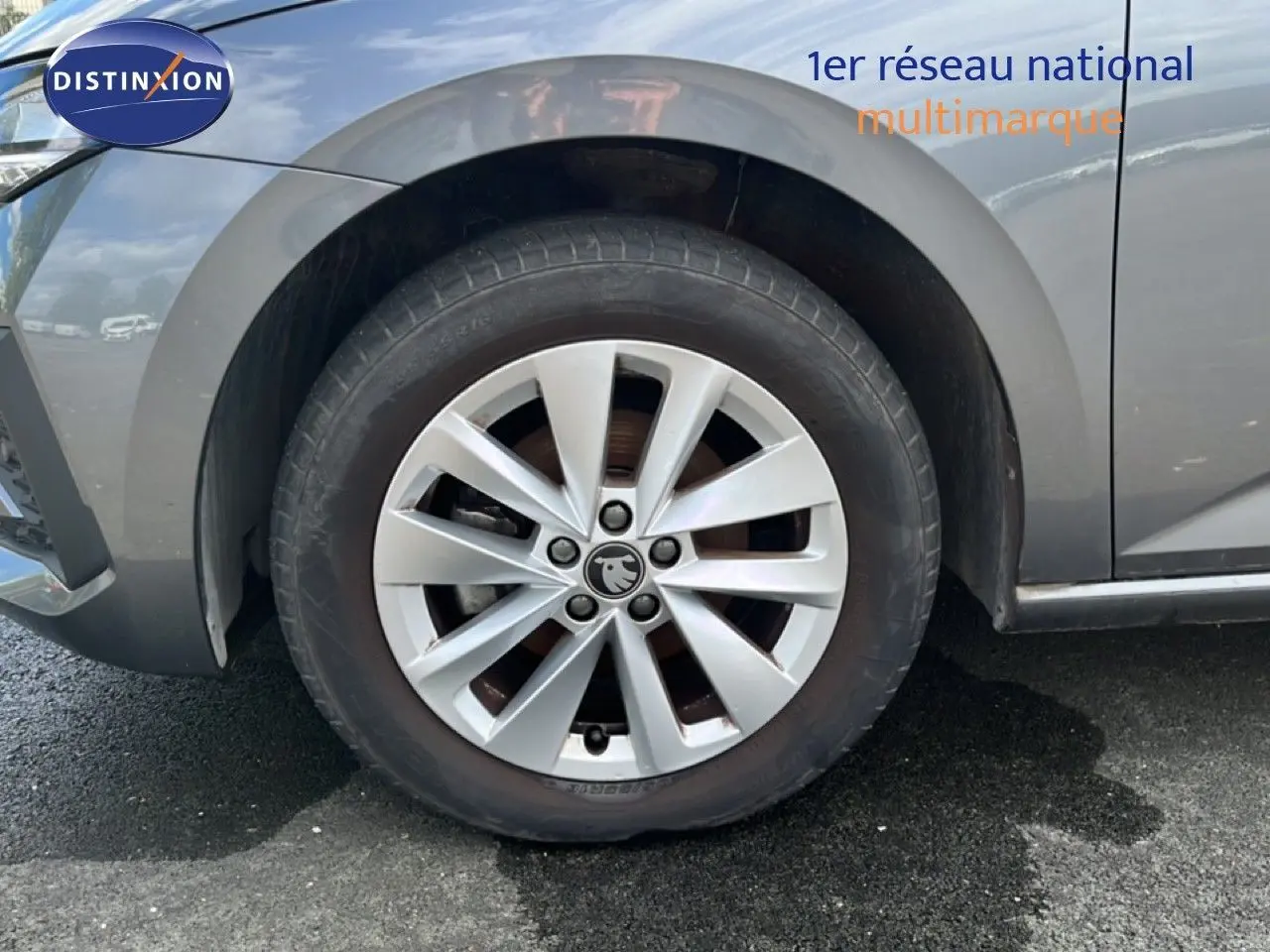 Gros plan sur la roue avant gauche d'une Skoda Scala gris magnétique métal avec jante alliage 16 pouces.