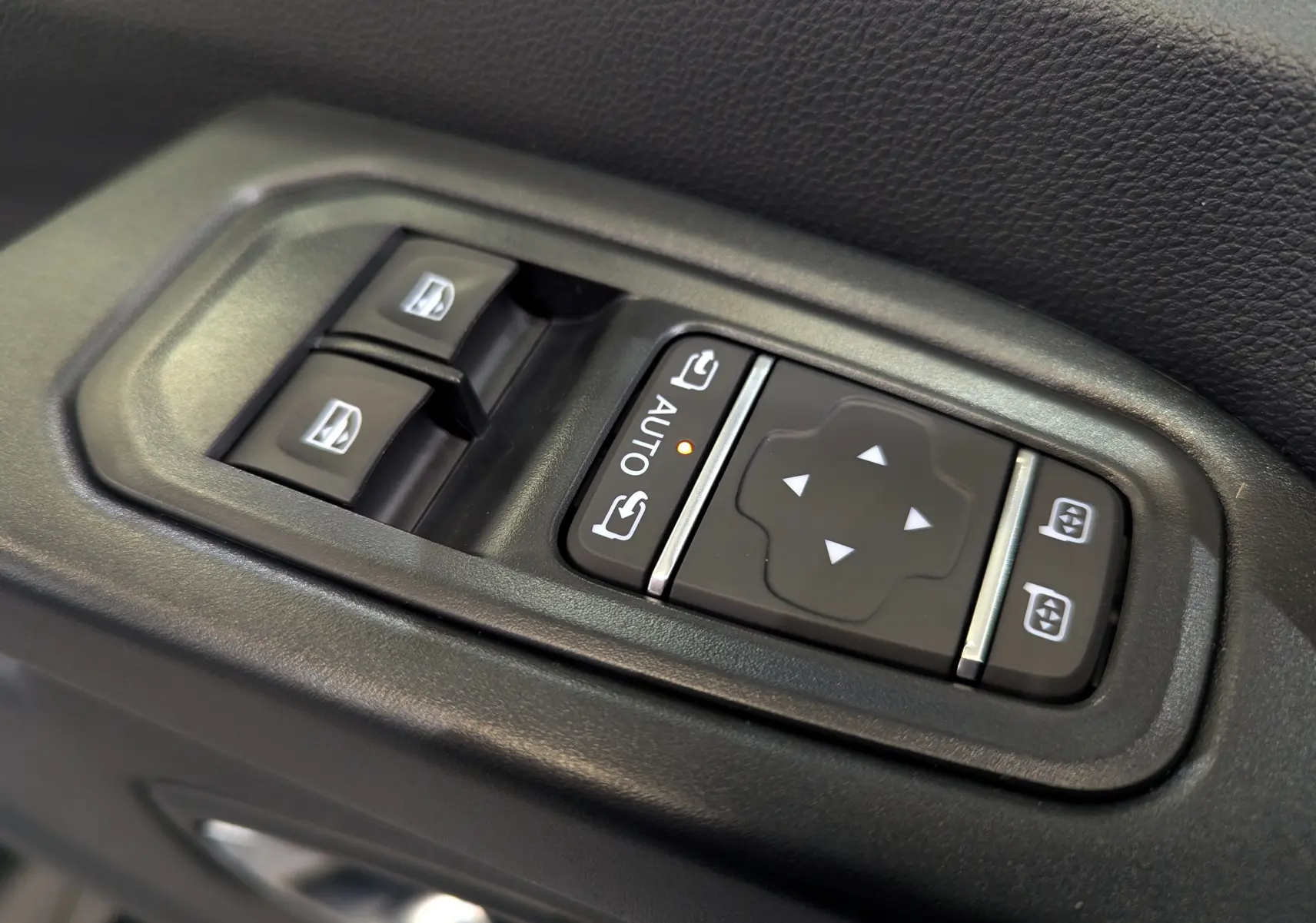 Gros plan sur les commandes de réglage des vitres et des rétroviseurs dans un Renault Trafic Fourgon gris urbain 2025.