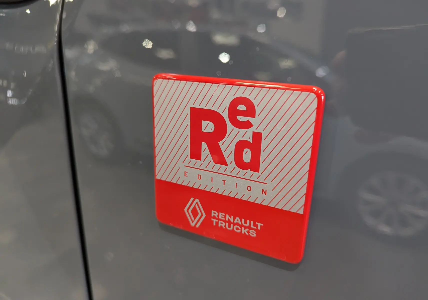 Gros plan sur l'écusson rouge et blanc "Red Edition" sur la porte gris urbain du Renault Trafic Fourgon L2H1 2025.