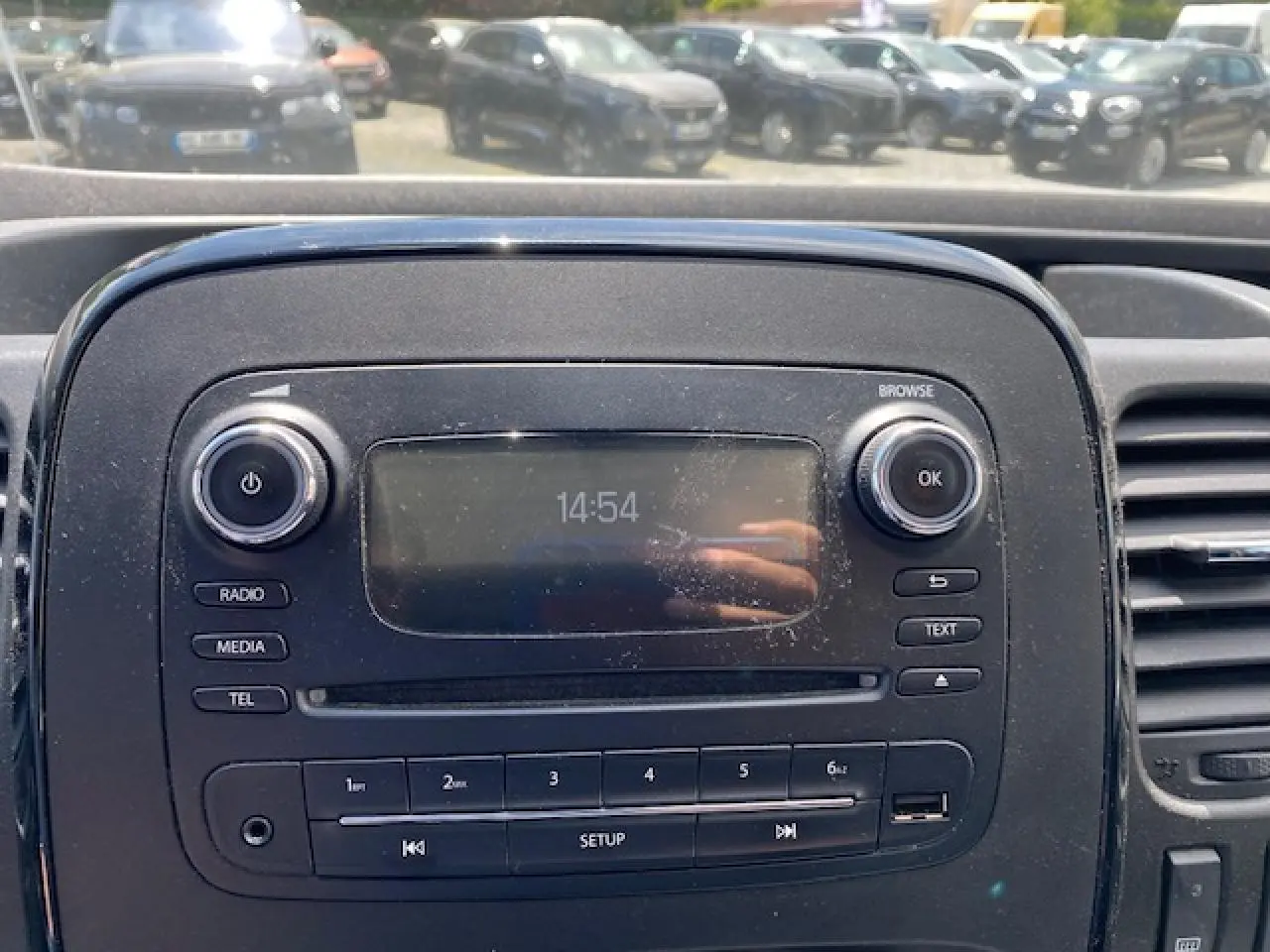 Console centrale de l'Opel Vivaro 2018 avec écran radio, boutons média et commandes intégrées, vue frontale rapprochée.