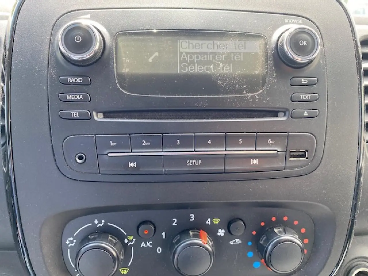 Vue rapprochée du tableau de bord de l'Opel Vivaro blanc 2018, mettant en valeur la radio et les commandes de climatisation.
