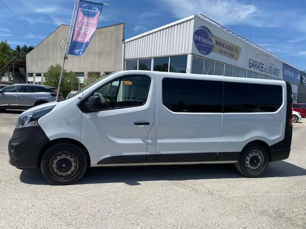 Profil droit d'un Opel Vivaro blanc 2018, version 9 places, avec vitres arrière teintées et pare-chocs noirs.