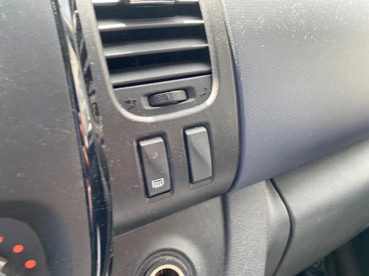 Détail du tableau de bord noir de l'Opel Vivaro 2018 montrant les commandes de ventilation et désembuage côté passager.
