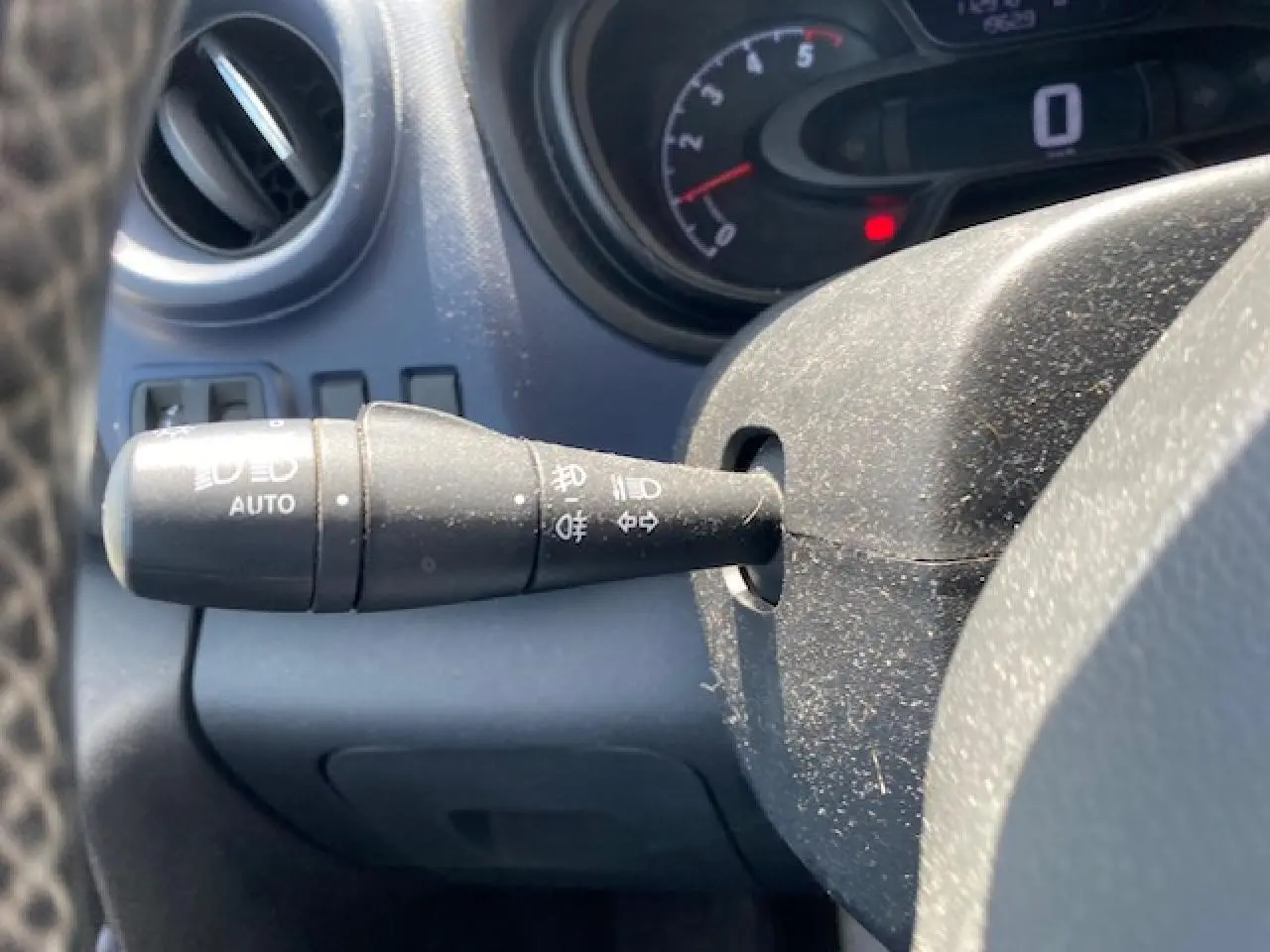 Gros plan sur la commande des phares automatiques à gauche du volant dans l'habitacle d'un Opel Vivaro blanc 2018.